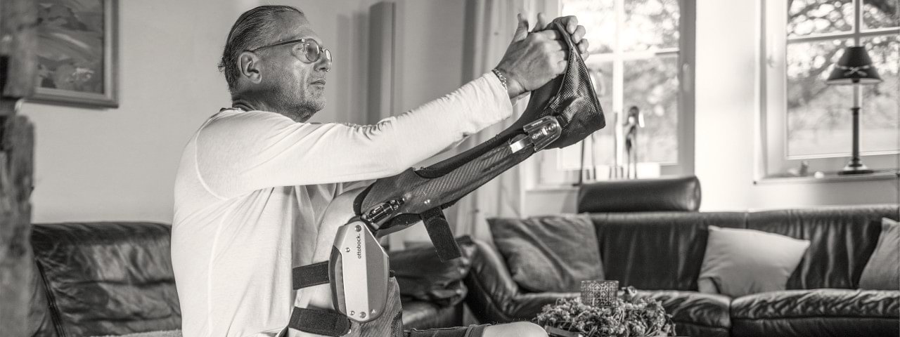 Wolfgang zieht sich seiner Orthese C-Brace® an.