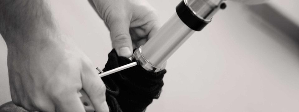 Hände schrauben an einem Prothesenfuß