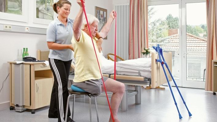 Therapeutin und Beinamputierter üben